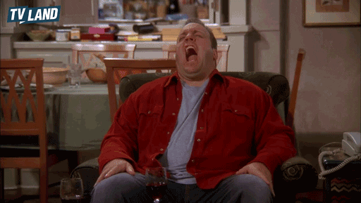 TV gif. Kevin James as Doug on King of Queens sits in an armchair and over-dramatically stretches his arms as he yawns like a lion roaring, then blinks and looks exhausted. 