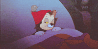 Cartoon gif. Figaro the cat in Pinocchio wears a red sleeping cap and is tucked in bed. He smacks his lips and closes his eyes. He opens one eye and then turns over to his side to sleep.