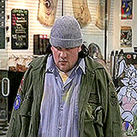 Movie gif. Kevin Smith as Silent Bob in Mallrats has a serious, almost dark expression on his face as he takes a big breath in. He then raises his head, tilts it back, and screams. 