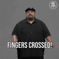 Celebrity gif. Gabriel Iglesias on the Youtube channel Answer the Internet, looks at us and holds both of his hands up with fingers crossed, saying, "Fingers crossed!"