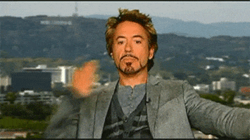 Celebrity gif. Robert Downey Jr. blows kisses to everyone and puts his hands out to spread his kisses around.
