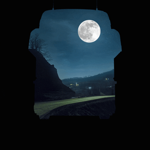 Digital compilation gif. We peer through at a road winding through a hilly landscape and full moon. The entire scene fits into the shape of a knight's helmet against a black background. Text, "Boa noite."