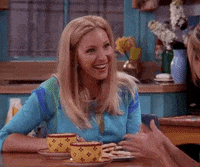Friends gif. Lisa Kudrow as Phoebe sits up straight, enthusiastically smiling and nodding.