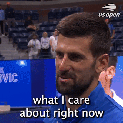 Video gif. Interview with Novak Djokovic shaking his head to one side with a slight smile and says, "What I care about right now is just to uhh... sleep." The US Open logo appears at the top corner. 