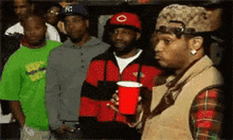 Celebrity gif. Reggie Sergile, also known as the rapper Conceited, holds a red cup and is listening to someone speak. He looks skeptical as he looks at us and puckers his lips exaggeratedly, looking down and swinging his body around to take a step away in doubt.