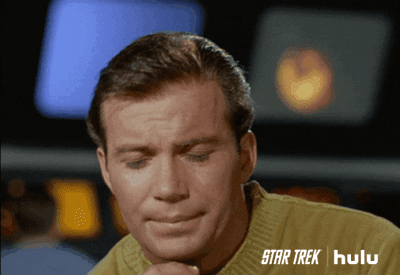 TV gif. Looking thoughtful, William Shatner as Captain Kirk in Star Trek rubs his chin as if he is considering something.
