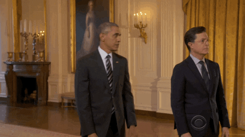 Political gif. From The Late Show with Stephen Colbert inside of the White House, Barack Obama walks backward, pointing his finger, as Colbert looks behind and notices him walking away.