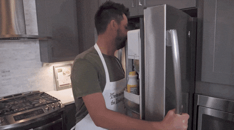Celebrity gif. John Crist pulls a head of iceberg lettuce from a fridge, raises his hand in praise and then says lettuce pray which appears as text.