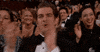 Celebrity gif. Andrew Garfield seated in the audience at the Oscars. His mouth opens wide like he's cheering as his hands clap in front of him energetically. 