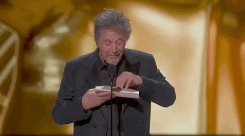 Oscars 2024 GIF. Like someone opening a candy wrapper, Al Pacino slowly unpeels the award envelope, and his eyes widen in excitement. He says, "My eyes see Oppenheimer."