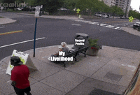 Meme gif. Garbage truck pulls up to a corner, on which is a large trash can positioned next to a bench on which an older woman is sitting. The truck's removal machine reaches out to grab the trash can but accidentally catches on to the bench, throwing the bench around and tossing the woman onto the ground. The truck is labeled "Billionaires," the garbage can is labeled "Record profits," and the woman is labeled "My livelihood."