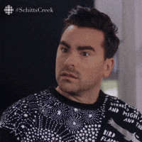 Schitt’s Creek gif. Dan Levy as David nods lightly as if absorbing some troubling information. His eyes dart around nervously, then he composes himself for a second to smile and speak. Text, "Yeah."