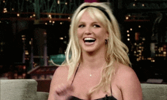 Celebrity gif. A dancing Britney Spears smiles happily.