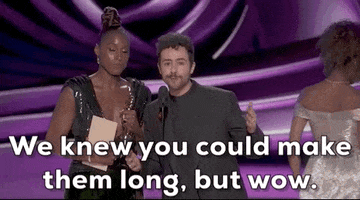Oscars 2024 gif. Issa Rae and Ramy stare at us directly as they address Wes Anderson for winning Best Short Film. They shake their head in disbelief and jokingly say, "We knew you could make them long, but wow."