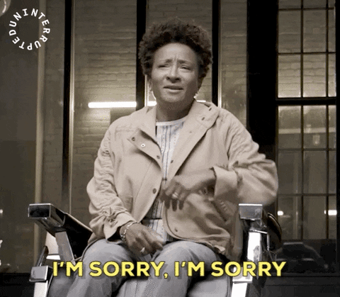 Video gif. Comedian Wanda Sykes sits in a chair, raises her hands and looks down pleadingly, but still in a lighthearted mood, saying “I'm sorry, I’m sorry”