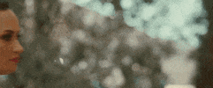 Music video gif. From Wiz Khalifa's video for Something New, Demi Lovato steps forward, turns to us and winks and smiles.