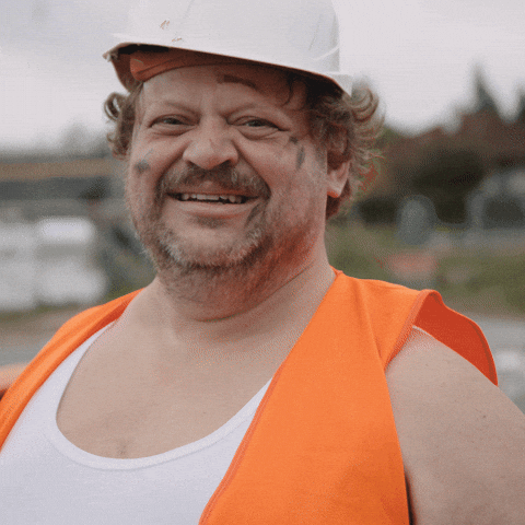 Tanzender Bauarbeiter mit Schaufel