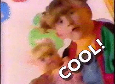 TV gif. Commercial from 1980s with a little girl holding a baby doll who looks at us and says "cool!" which appears as text.