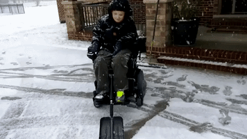 Determined Boy Uses His Wheelchair as Snowplow