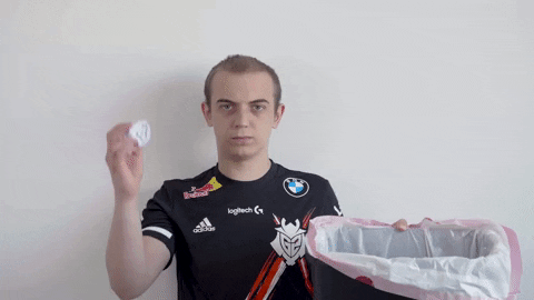 Video gif. Caps the Danish gamer stands unimpressed as he tosses a crumpled up piece of paper in a trash bin. 
