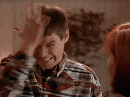 Movie gif. Jim Carrey as Lloyd from Dumb and Dumber slaps his forehead in frustration.