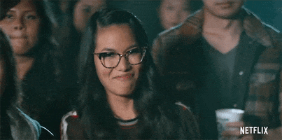 Movie gif. Ali Wong as Sasha Tran in Always Be My Maybe stands among an audience while pointing and smiling in an affirmative way.