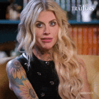 Sponsored gif. Traitors cast member Carolyn Wiger cringes awkwardly.