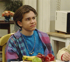 TV gif. Rider Strong as Shawn Hunter in Boy Meets World chews his food while appearing slightly confused.