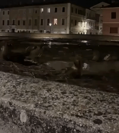 Swollen River Sweeps Debris Against Bridge in Flood-Hit Italian Town