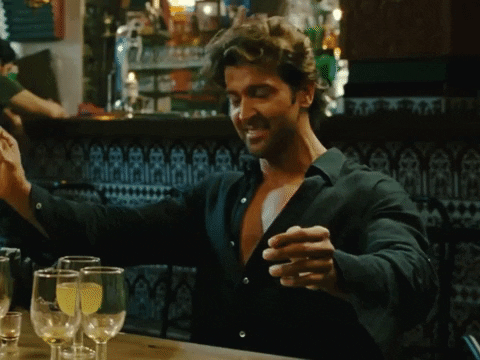 Movie gif. Hrithik Roshan as Arjun in Zindagi Na Milegi Dobara. He's consumed several glasses of wine and plays the air drums before finishing off with a flick of his wrist. His eyes are closed the whole time he does this and his shirt is buttoned low on his shapely chest.