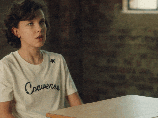Ad gif. Millie Bobby Brown slams her hands on a desk, shaking her head and rolling her eyes in exaggerated exasperation in a Converse commercial.