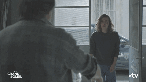 TV gif. Christophe Favre as Gérald in Un Si Grand Soleil. He walks into a building looking tattered and he is immediately hugged by another gentleman. Once embracing, he breaks down into a sob.