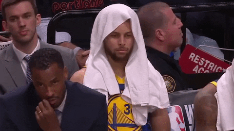 Sports gif. Steph Curry wears a towel over his head as he gazes blankly as if zoned out. 