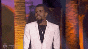 Celebrity gif. Brandon Leake points from the stage triumphantly, in tribute.