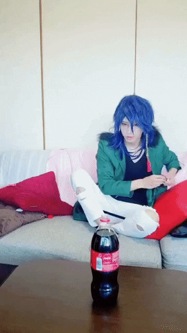 Video gif. Person with blue hair casually tosses a Mentos into a Coke bottle and freaks out when it starts to bubble up. They try to put their mouth over the bottle in an attempt to drink up the fizz.