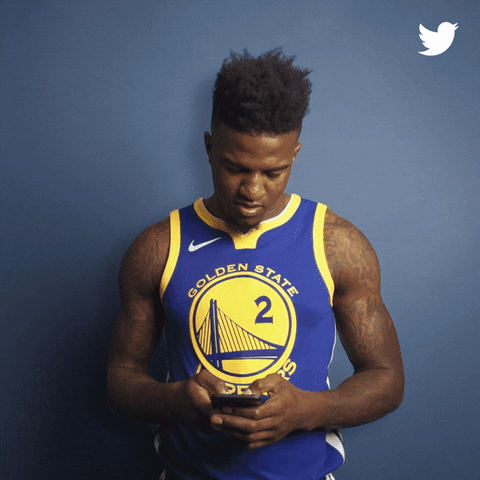 Sports gif. Basketball player Jordan Bell types on a smartphone, then shakes his head in annoyance while the words "smh" increases and enlarges on the wall behind him.