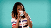 Celebrity gif. Franchesca Ramsey takes a sip from a tea cup and forcefully blinks her eyes  as she lowers the cup. 