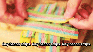Meme gif. On a cutting board, a person layers Rainbow Candy Belts in a lattice pattern. Text, "Gay bacon strips. Gay bacon strips. Gay bacon strips."