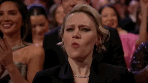 Oscars 2024 GIF. Kate McKinnon, at the Oscars, loudly cheers “Woooooo!”