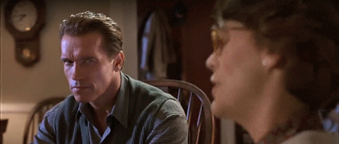 Movie gif. Arnold Schwarzenegger as Harry in True Lies. He sits in a chair listening to someone but is extremely skeptical, narrowing his eyes and staring at them intensely. The camera pans in on his face and zooms deeply, until his skeptical face fills the whole screen.