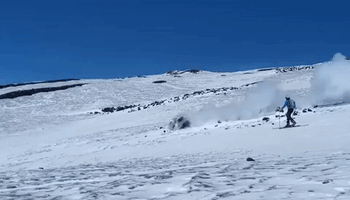 Skiers Follow Smoldering Boulder as It Rolls Down Mount Etna