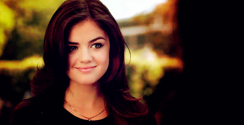 TV gif. Lucy Hale as Aria in Pretty Little Liars smiles sweetly.