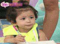 Video gif. A young toddler on a Korean show has a frustrated look on her face. She holds a marker with one hand and holds her other hand up. She yells, “Stop, stop!”