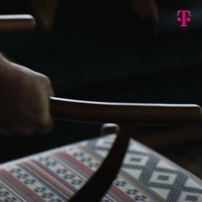 Ad gif. Rainn Wilson in an ad for T-Mobile picks up a chair and throws it out the window of a midcentury modern house.