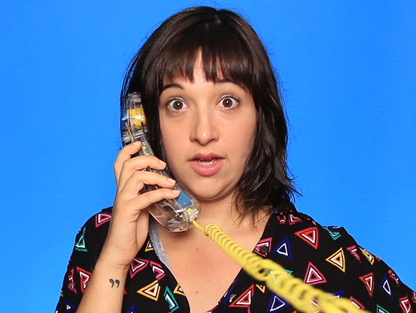 Video gif. Woman holds a telephone to her ear, staring at us wide-eyed and mouthing "wow."