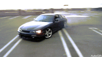 Video gif. A black Nissan Silvia s14 pulls donuts across a mostly-empty parking lot.