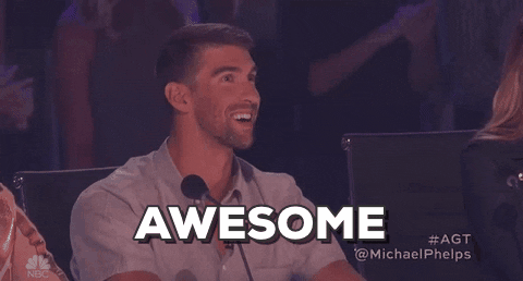 Reality TV gif. Michael Phelps as a Judge on America’s Got Talent looks up at the stage in awe. He has a wide grin on his face as he says, “Awesome.”