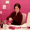 Video gif. A woman behind a desk, punches the air excitedly as she spins with cheer in her chair. 