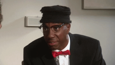 TV gif. J.B. Smoove as Leon in Curb Your Enthusiasm. He wears a suit and a red bowtie and he leans back with a smile before frowning deeply and looking shocked.
