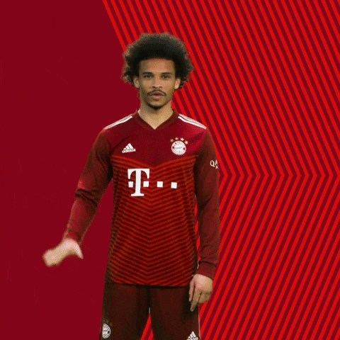 Sports gif. Wearing a red uniform with sponsorship logos, Leroy Sane smiles and waves at us.